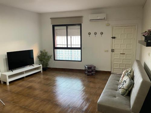 a living room with a couch and a flat screen tv at Apartamento monte dorado in Málaga