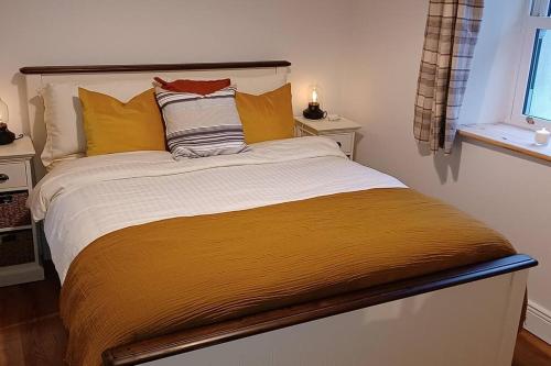um quarto com uma cama grande e almofadas amarelas em Foxglove Lodge 