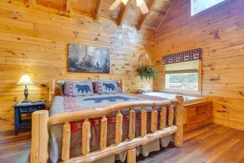 ein Schlafzimmer mit einem Bett in einem Blockhaus in der Unterkunft Pigeon Forge Cabin with Hot Tub 5 Mi to Dollywood in Pigeon Forge