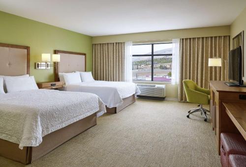 a hotel room with two beds and a television at Hampton Inn & Suites Silverthorne in Silverthorne