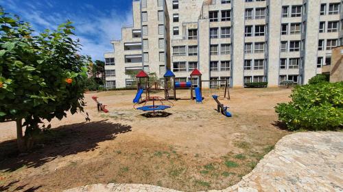 a playground in front of a large building at Margarita & More, Omas in Porlamar