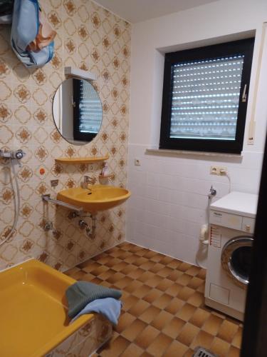 a bathroom with a sink and a washing machine at Monteurwohnung Wiedenmann in Koetz 