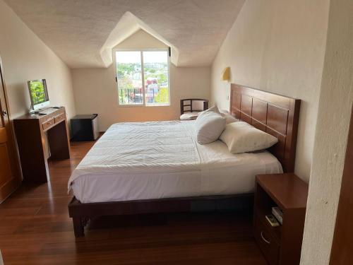 um quarto com uma cama grande e uma janela em Xtabentun Hostal em Cancún