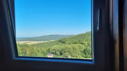 a window with a view of a mountain at Penzion Zvonice Hojná Voda in Horní Stropnice