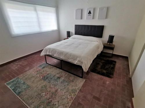 a bedroom with a bed and a window and a rug at Residencial Oaxaca Centro in Oaxaca City