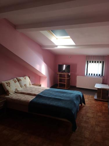 a bedroom with a large bed in a pink room at Pensiunea Mikelis International in Curtea de Argeş
