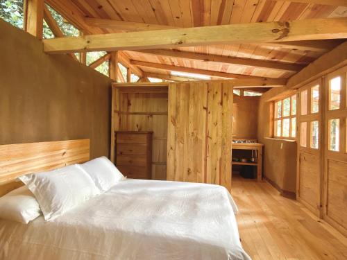 sypialnia z białym łóżkiem i drewnianym sufitem w obiekcie Casa Sierra y Casita Sierra 