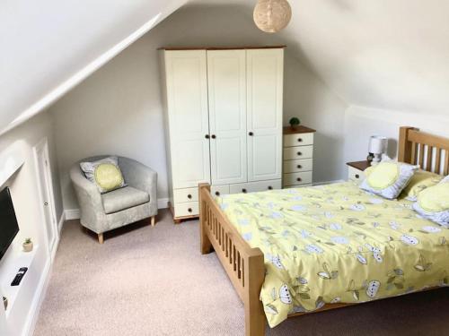 a bedroom with a bed and a chair at Mendip Edge Retreat in Farrington Gurney