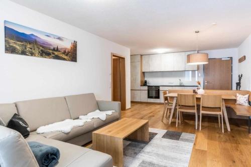 uma sala de estar com um sofá e uma mesa em Faschina Apartment - Top 4 em Fontanella