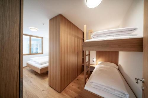 a bedroom with two bunk beds and a doorway at Faschina Apartment - Top 4 in Fontanella