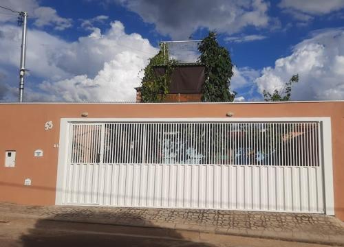 a large white garage door with ivy on a building at Casa Topázio no Container dos Cristais in Delfinópolis