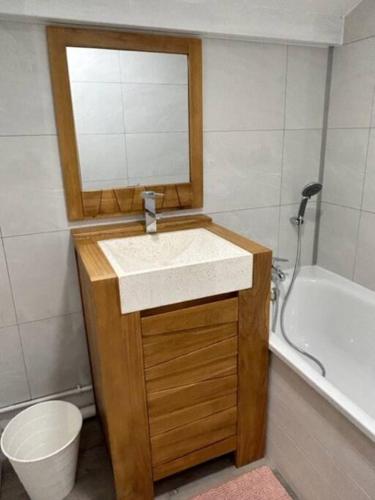 une salle de bain avec un lavabo, un miroir et une baignoire dans l'établissement Praz sur Arly - proche des pistes et de Megève, à Praz-sur-Arly