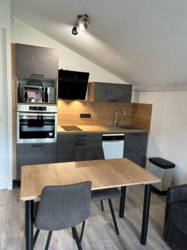 - une cuisine avec une table en bois et un évier dans l'établissement Praz sur Arly - proche des pistes et de Megève, à Praz-sur-Arly