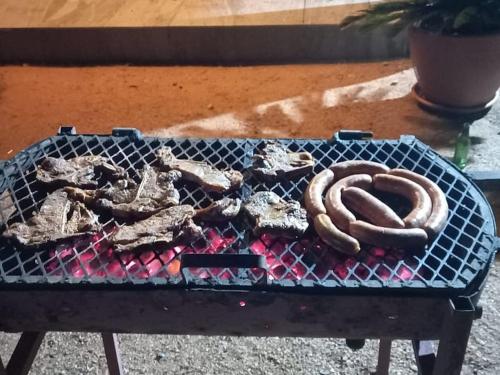 a grill with a pretzel and meat on it at Serene Cottage in Francistown