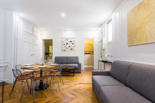 un salon avec une table et un canapé dans l'établissement Appartement accueillant -1BR-6P - Auteuil - Passy, à Paris