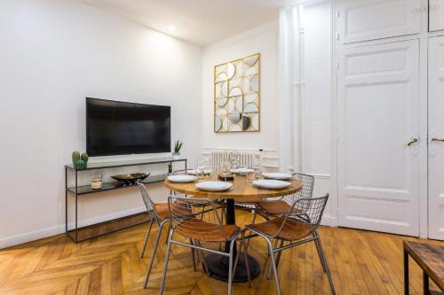 une salle à manger avec une table, des chaises et une télévision dans l'établissement Appartement accueillant -1BR-6P - Auteuil - Passy, à Paris