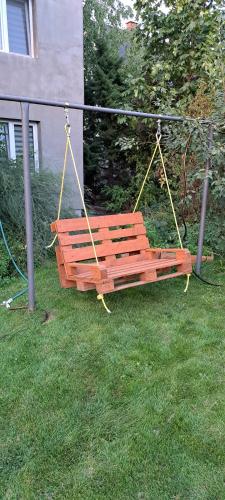 a wooden swing sitting in the grass in a yard at Pokoje Bema 14 in Ciechocinek
