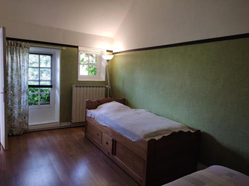 - une petite chambre avec un lit et une fenêtre dans l'établissement Les Glycines, à Vulaines-sur-Seine