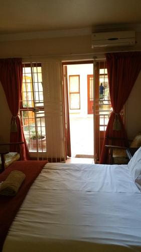 ein Schlafzimmer mit einem Bett und einem großen Fenster in der Unterkunft Harties Lodge - Bay View 5 in Hartbeespoort