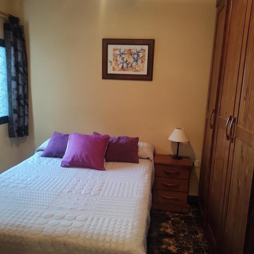 - une chambre avec un lit blanc et des oreillers violets dans l'établissement CASA ROSAMAR, à Agulo