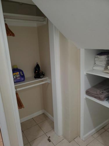 a walk in closet with white shelves and towels at STS - Single Traveler Studio -Black Door in Washington, D.C.