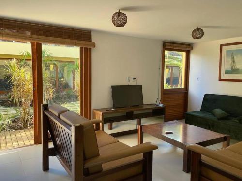 ein Wohnzimmer mit Sofa und Fernseher in der Unterkunft VILA BOMBACA - 100m da praia in Barra Grande