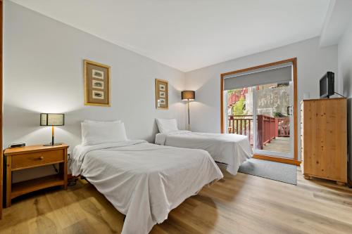 a bedroom with two beds and a window at Haut-Bois by Rendez-Vous Mont-Tremblant in Mont-Tremblant