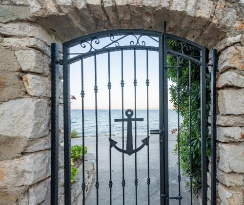 an iron gate with an anchor on the beach at Home with a unique view in Preko