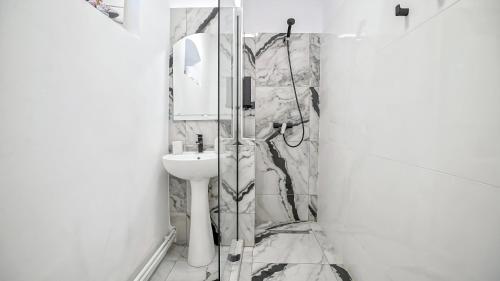 y baño con ducha y lavamanos. en Comfort Apartment Barițiu Brașov, en Brasov