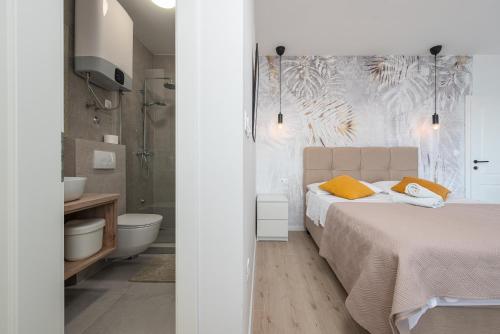 ein weißes Schlafzimmer mit einem Bett und einem Badezimmer in der Unterkunft Home with a unique view in Preko
