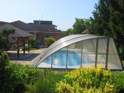 a swimming pool in a dome tent in front of a house at Fészek Apartmanház in Vonyarcvashegy