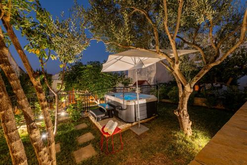a backyard with a bed and an umbrella at Home with a unique view in Preko