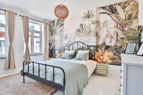 1 dormitorio con 1 cama con papel pintado tropical en Logement hypercentre de Spa, en Spa