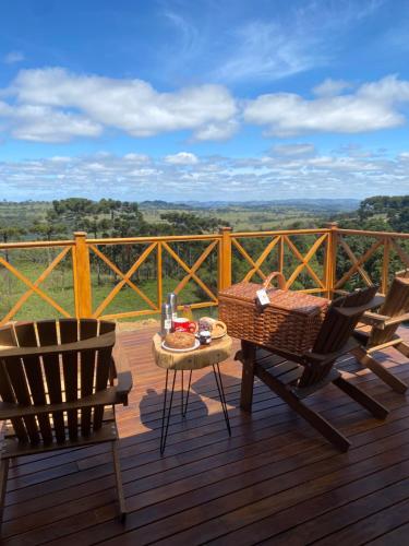 een terras met een tafel en stoelen op een dek bij Tenuta Bergamaschi in São Joaquim