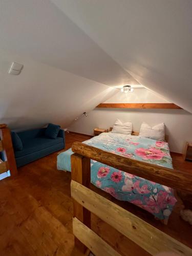 ein Schlafzimmer mit einem Bett und einem Sofa im Dachgeschoss in der Unterkunft Domki Pod Brzoza in Idzików