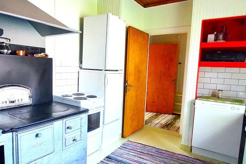 a kitchen with a white refrigerator and a stove at Villa Mummola Neljän makuuhuoneen asunto lähellä jokea in Simpele