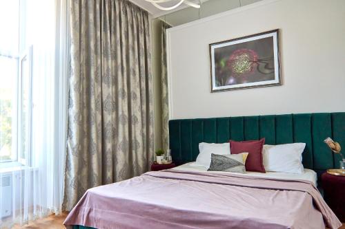 - une chambre avec un lit doté d'une tête de lit verte dans l'établissement Стильні Апартаменти на Ратушній площі, à Moukatcheve