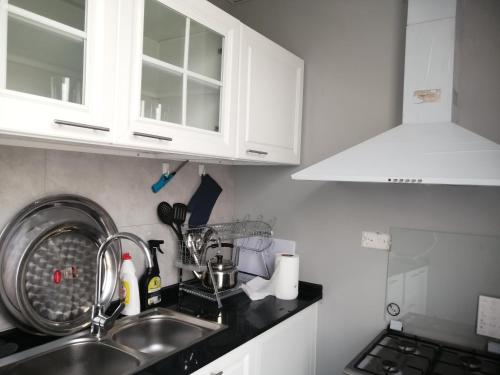 a kitchen with white cabinets and a sink at مزرعة واستراحة المنامة 
