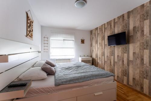um quarto com uma cama e uma parede de madeira em Apartment Borik em Bjelovar