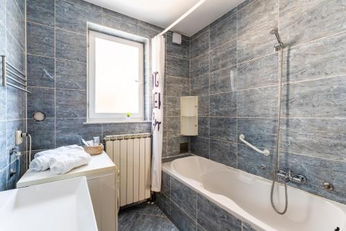 a bathroom with a tub and a shower and a sink at Apartman Borik in Bjelovar