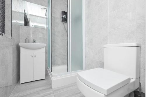 Baño blanco con aseo y lavamanos en 3 Bed Notts City Centre Town House - Free parking en Nottingham