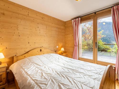 1 dormitorio con cama y ventana grande en Chalet La Clusaz, 6 pièces, 8 personnes - FR-1-459-186 en La Clusaz