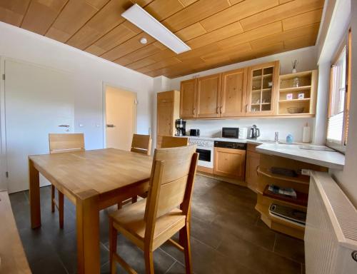 eine Küche mit einem Holztisch und Holzschränken in der Unterkunft Apartmenthaus RuheZeit in Bad Endbach