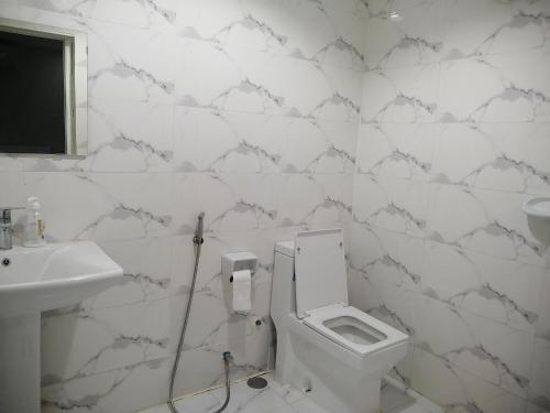 a white bathroom with a toilet and a sink at مزرعة واستراحة المنامة 
