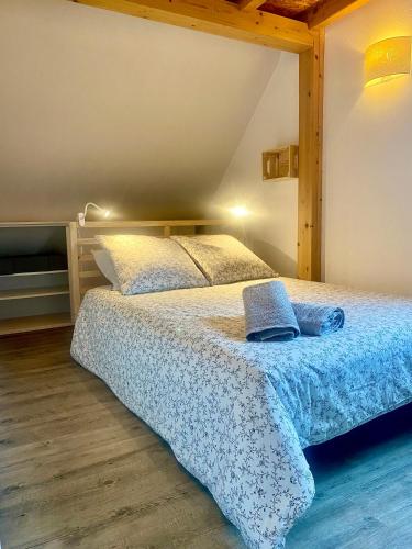 une chambre avec un lit avec une couverture bleue dans l'établissement Meublé de la Doller - Chalet au bord de l’eau, à Masevaux