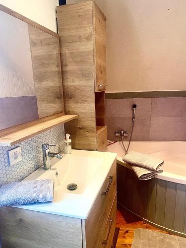 - une cuisine avec un évier et une baignoire dans l'établissement Meublé de la Doller - Chalet au bord de l’eau, à Masevaux