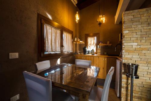 a dining room with a wooden table and white chairs at TENUTA I TUFARI in Tivoli