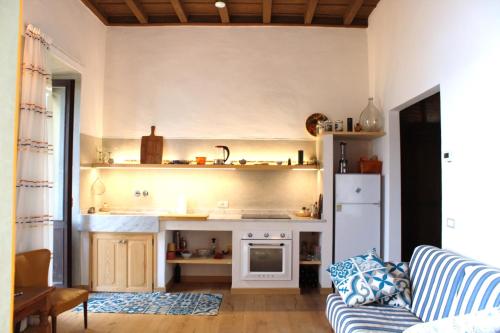 ein Wohnzimmer mit einem Sofa und einer Küche in der Unterkunft Namaste apartment Fiumelatte in Varenna