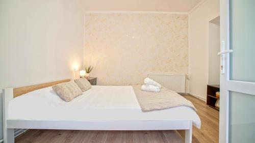 Un dormitorio con una cama blanca con un osito de peluche. en Comfort Apartment Barițiu Brașov en Braşov