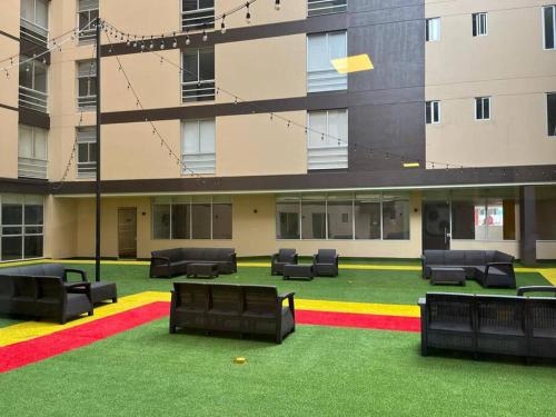 a large building with black chairs and a green yard at living ventto calle 18 in Bogotá